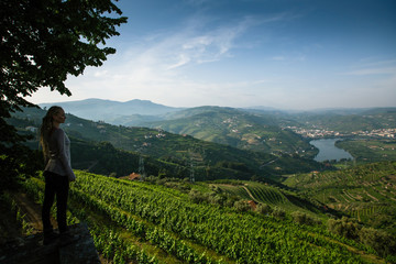 Woman from the hill looks at on of the Douro Valley, Porto, Portugal. - obrazy, fototapety, plakaty