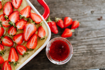 Strawberry cake and yogurt with strawberry jam on the dark wooden background