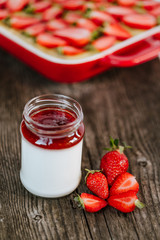 Strawberry cake and yogurt with strawberry jam on the dark wooden background