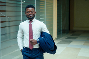 african american man holding big smartphone and posing in shoping mall hall