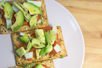 healthy toast with tomato avocado and cheese on wooden table
