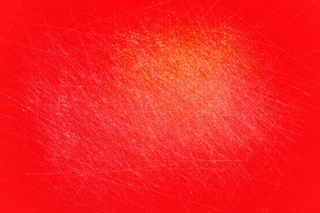 Red, plastic, grained cutting board with a lot of scratches.