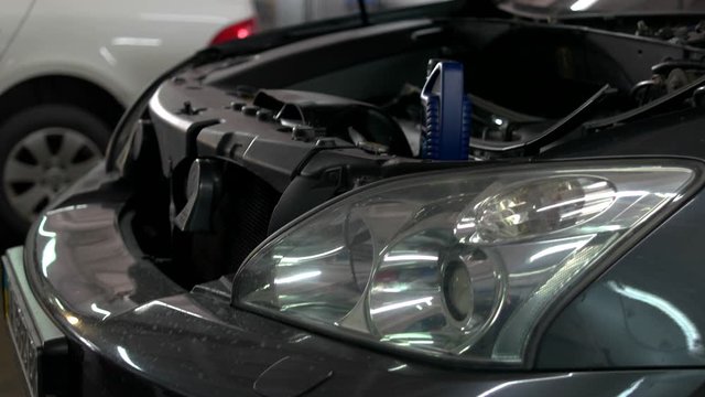 Open car hood. Car engine amd headlight close-up. Concept of car repair shop, car repair, breakdown.
