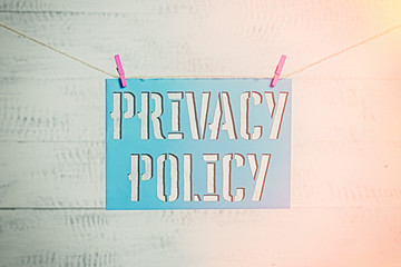 Handwriting text Privacy Policy. Conceptual photo Document that explains how an organization handles clients Clothesline clothespin rectangle shaped paper reminder white wood desk