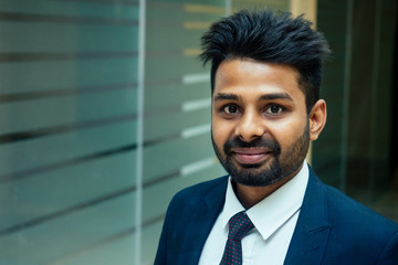 well-dressed business indian men making a report to subordinate employees in a modern office