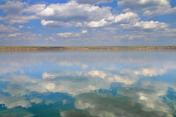 The photo was taken on the estuary, near the city of Odessa. The image shows a cloudy sky reflection on the surface of the estuary.