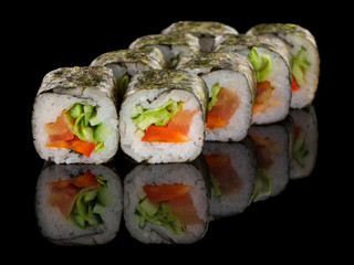 Vegetarian Sushi roll with vegetables: pepper, cucumber, avocado and salad isolated on black background with reflection