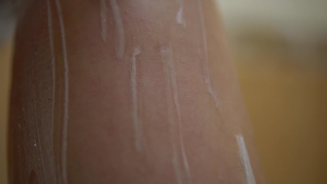 Woman shawing leg by razor and shawing foam, close up, depilation in bath