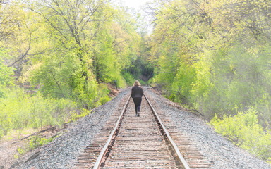 A person is walking along a abandoned railroad 