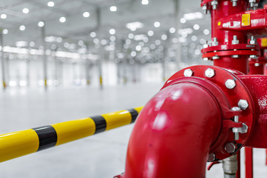 fire suppresion system in a empty industrial hall red pipes and bariers