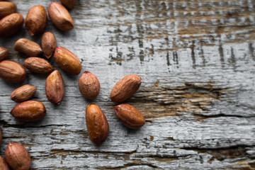 Peanut nuts scattered on the wooden vintage table. Peanuts nut is a healthy vegetarian protein nutritious food.