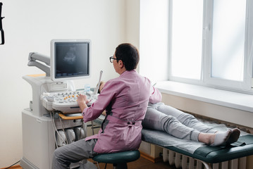 A pregnant girl gets an ultrasound of her abdomen at the clinic. Medical examination