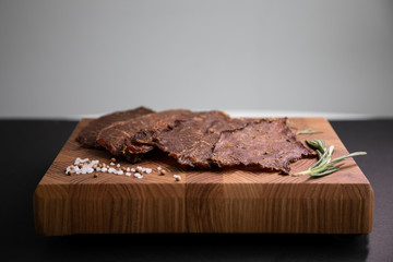Close-up of a piece of meat on a wooden Board with spices. Restaurant menu, a series of photos of different dishes