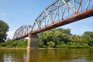 Old railway bridge over a river, rusty metal grid