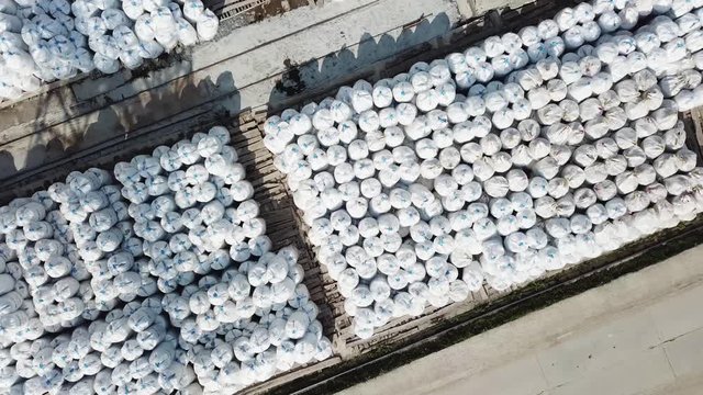 Top view of an open air warehouse with packed materials at the industrial city zone. Stock footage. Aerial view of many rows of packed insulation materials.