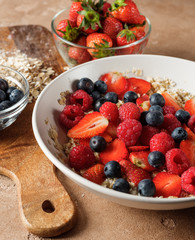 Healthy and diet traditional homemade breakfast - oatmeal flakes with fresh fruits strawberries and blueberries. Healthy lifestyle food homemade recipe.