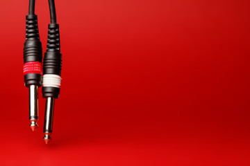 Two audio cables on a red background