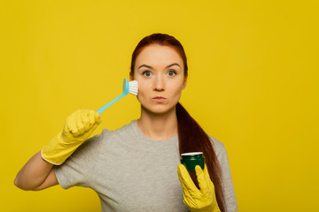 Beauty Face Skin Care. Closeup Young Woman In Yellow Gloves And Cleaning Brush In Hand Exfoliating Skin. Portrait Of Beautiful Healthy Girl With Natural Makeup Scrubbing Facial Skin