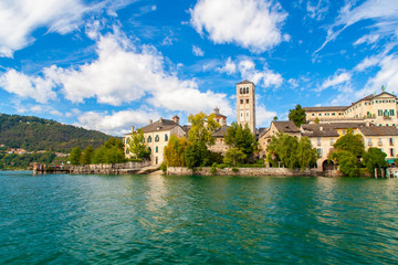 Fototapeta na wymiar Vista degli edifici dell'Isola di San Giulio nel lago d'Orta, dal pelo dell'acqua, Piemonte, Italia
