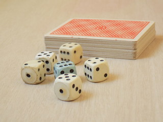Dados junto a juego de naipes