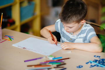 A school-age boy does homework at home. Training at school