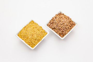 Brown and golden flax seeds isolated on white background