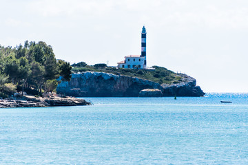 View of the port and the lighthouse with blue sky, Portocolom, Mallorca