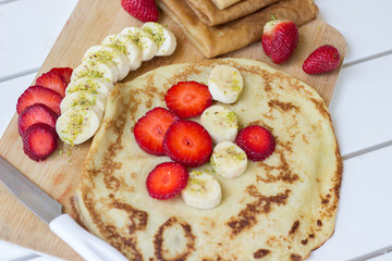 Pancakes filled with fresh strawberries and banana - 347629159
