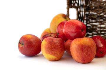 Red apples close up. Fresh organic fruits in a wicker basket isolated on white background with copy space.