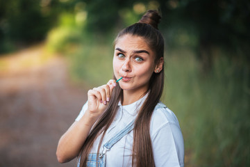 Girl with a candy on a stick on the nature