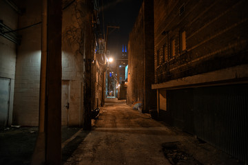 Fototapeta na wymiar Dark and eerie urban city alley at night