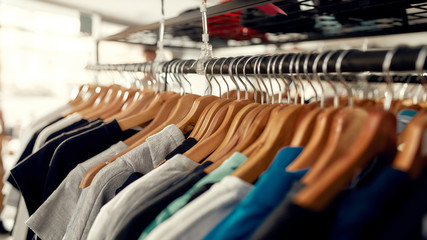 Wide range. Close up of clothes rack or rail in the store. Items at custom T-shirt, clothing...