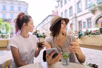 Talking and drinking soft drinks mother daughter teenager