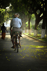 Obraz premium An old village man going for work on a bicycle in the morning