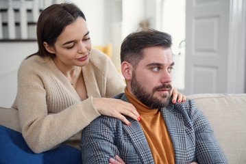 Fototapeta premium Attractive woman apologizing to frustrated man after quarrel, doubting boyfriend ignore, girlfriend feeling guilty, asking forgive her, begging pardon, admits mistake, regret, couple having problem