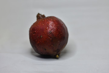 red pomegranate on a white background, and the water drops on a pomegranate, Indian Fruit 