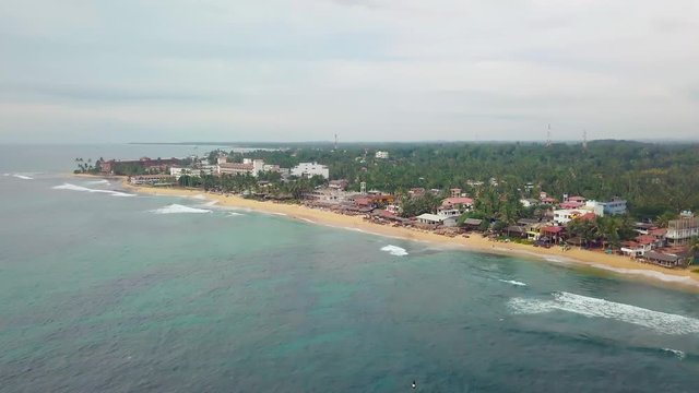 Aerial view of cozy white sand beach with turquoise clear sea water. Sri Lanka beach view from the air, Mirissa 