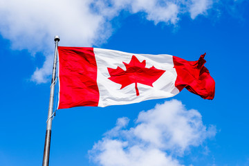 Waving Canadian flag with blue sky in background