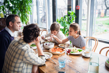 A family of four are having lunch on a spacious porch