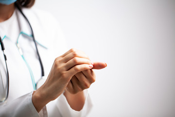 Female doctor in a white coat disinfects her hands with antiseptic