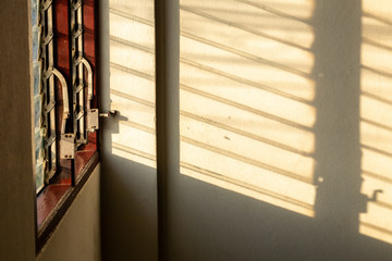 Sunlight shadow on the wall with old louver windows.