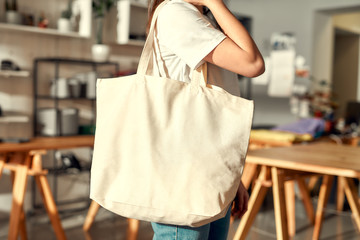 For your brand. Cropped shot of female worker posing with custom shopper bag in the store. Young...