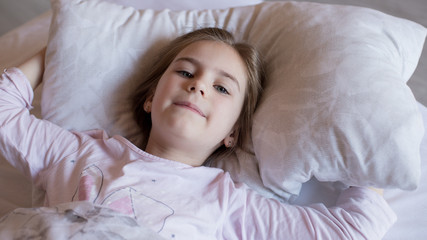 Cute little girl in bed woke up in the morning