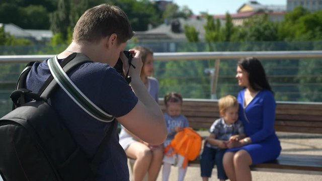 Photographer Shooting Taking Pictures of Mothers with Children. Backstage Photo Session on Pedestrian Bridge on Cityscape Background