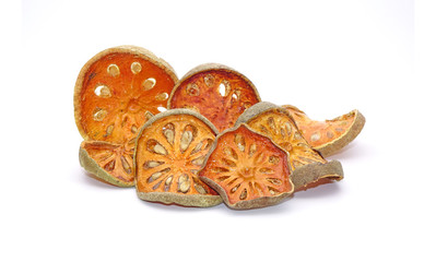 Dried sliced Bael fruit isolated on white background. Bael fruit has anti-inflammatory property, helps to heal digestive disorders, used as a remedy for asthma, and common cold. Herbal tea ingredients
