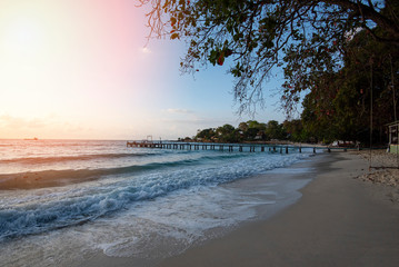 Amazing sandy tropical beach with silhouette wooden bridge out of the beach tropical boardwalk or Wooden walkway to the horizon on sea ocean paradise landscape , sunrise or sunset sea dramatic sky