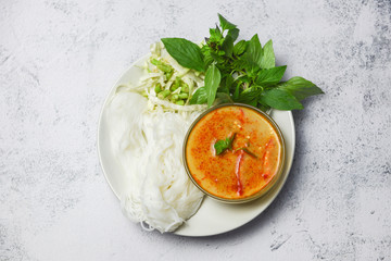 Curry cuisine asian food on the table - Thai food curry soup bowl with thai rice noodles vermicelli ingredient herb vegetable on white plate