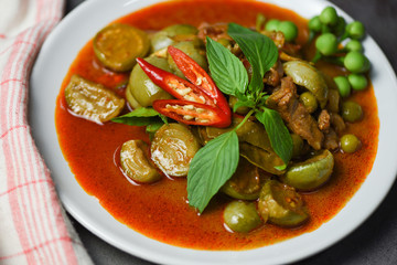 Thai food curry soup on white plate - red curry pork cuisine asian food on the table background