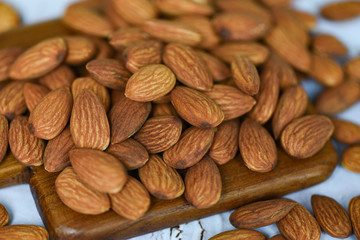 Roasted almond for snack - Almonds nuts on wooden board background top view