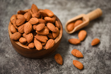 Almonds nuts on wooden bowl on dark background , top view - Roasted almond for snack